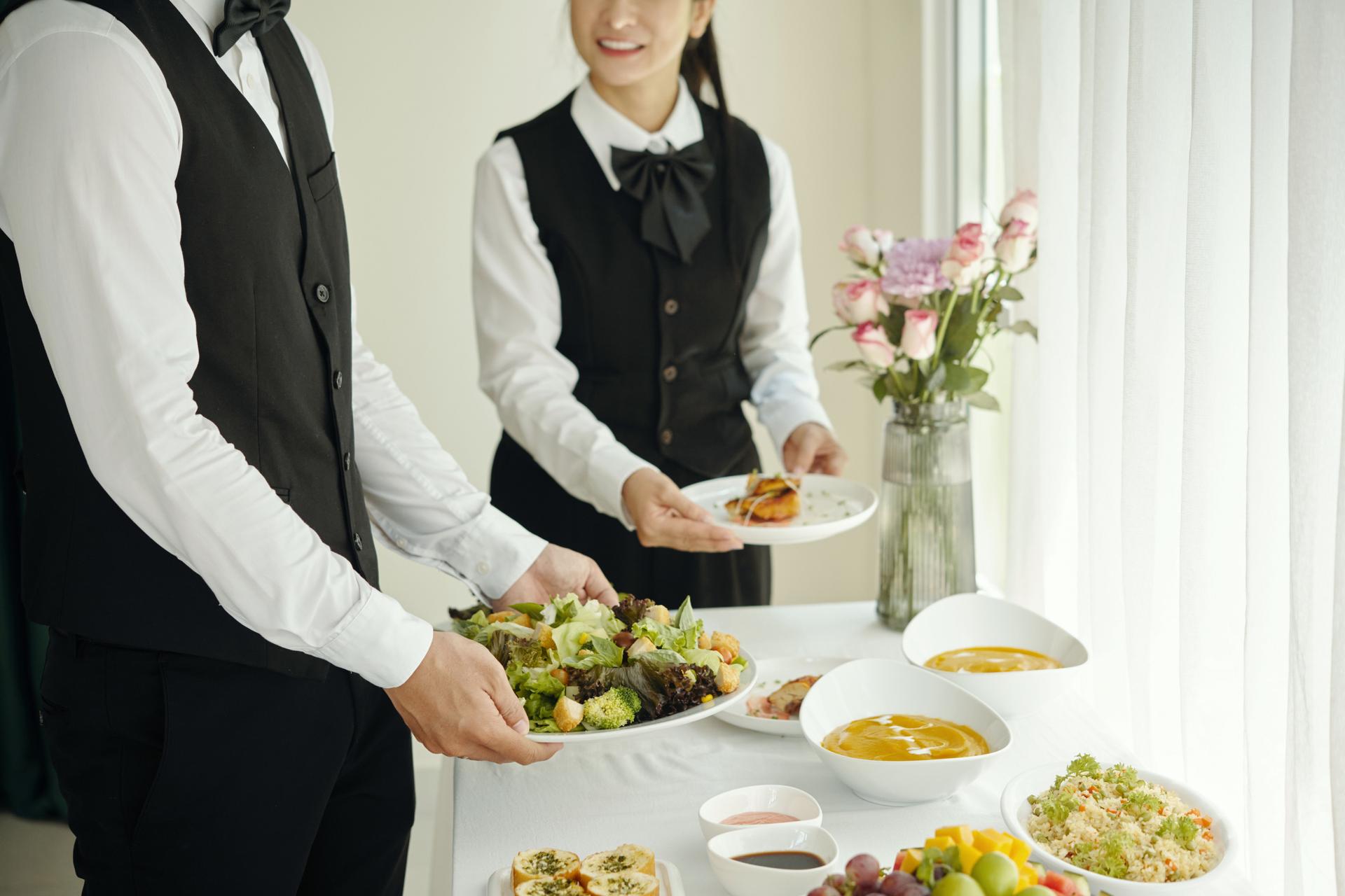Waiters Arranging Dining Table At Catering Service